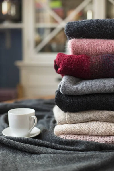 Yan, arka plan kopya alanı, rahat hygge duvar kağıdı ile sıcak içecek beyaz Kupası ile renkli kazak yığını.