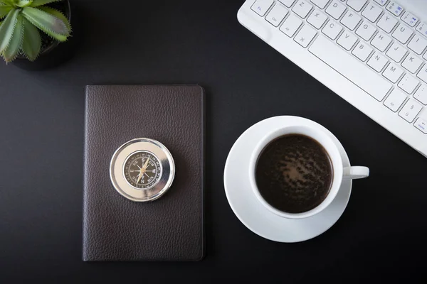 Working desk top view with coffee and compass.