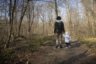 Baba ve bebek kırsal yolda yürüyor.