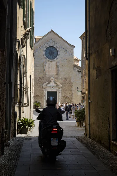 Gasse mit Blick auf die Kathedrale von Albenga mit einer Person auf einem — Stockfoto