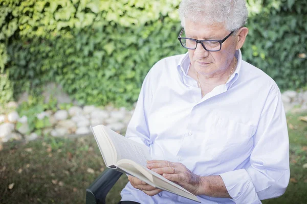 older man reading outside