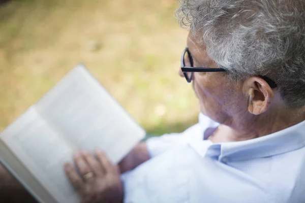 older man reading outside