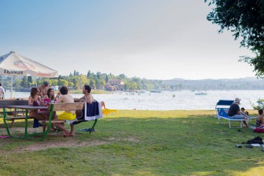 San Biagio Adası, Manerba del Garda, Lombardy, İtalya 'da içki içen insanlar..
