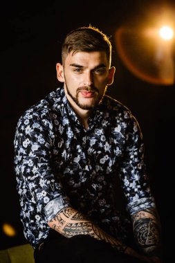 Stüdyoda poz veren genç yakışıklı adam.