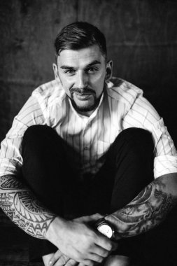 stüdyoda oturan genç yakışıklı adam