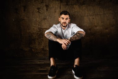 stüdyoda oturan genç yakışıklı adam