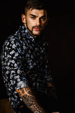 Stüdyoda poz veren genç yakışıklı adam.