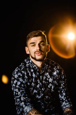 Stüdyoda poz veren genç yakışıklı adam.