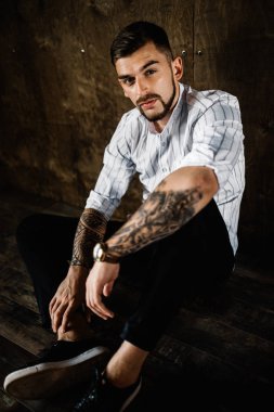 stüdyoda oturan genç yakışıklı adam