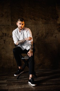 stüdyoda oturan genç yakışıklı adam