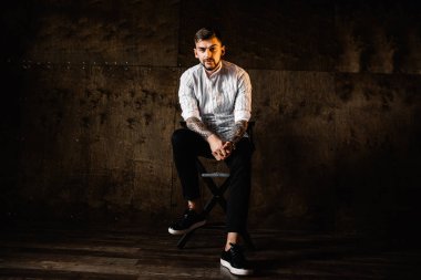 stüdyoda oturan genç yakışıklı adam