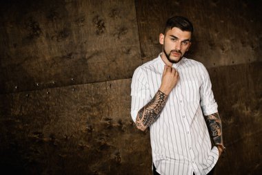 Stüdyoda poz veren genç yakışıklı adam.