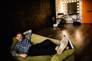 Genç yakışıklı adam kanepede poz