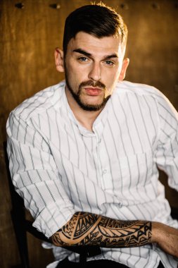 Stüdyoda poz veren genç yakışıklı adam.