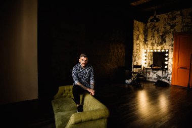 Genç yakışıklı adam kanepede poz