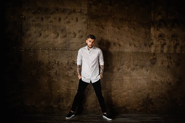 Stüdyoda poz veren genç yakışıklı adam.