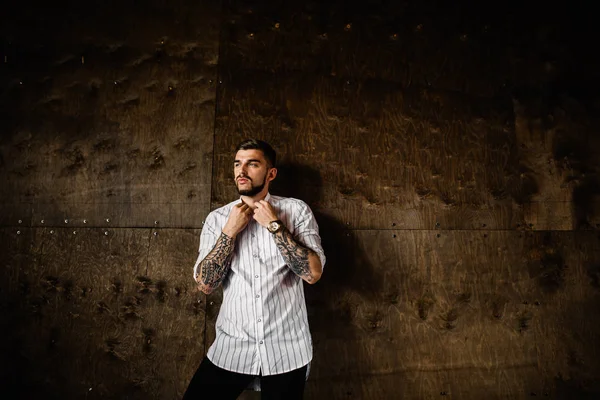 Stüdyoda poz veren genç yakışıklı adam.