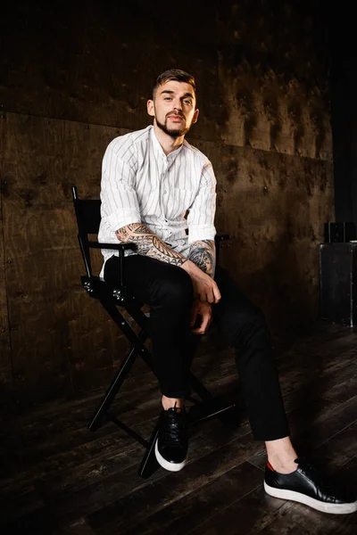 stüdyoda oturan genç yakışıklı adam