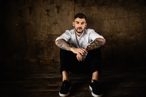 stüdyoda oturan genç yakışıklı adam