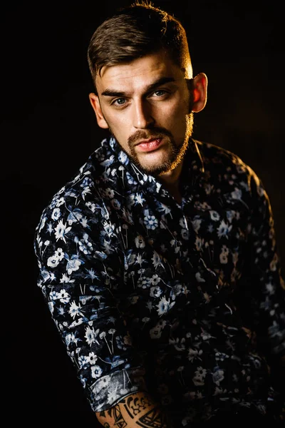 Stüdyoda poz veren genç yakışıklı adam.