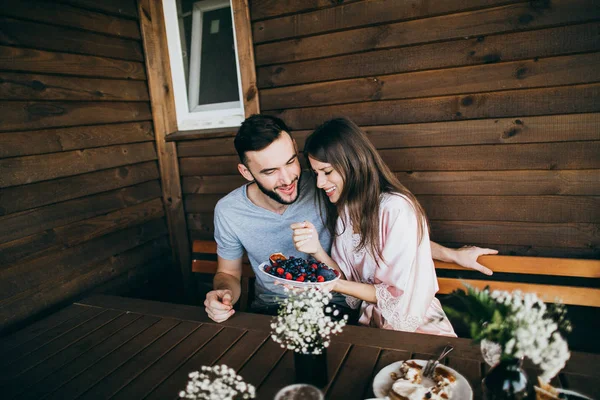 Happy beautiful young  couple  having breakfast. woman feeding man