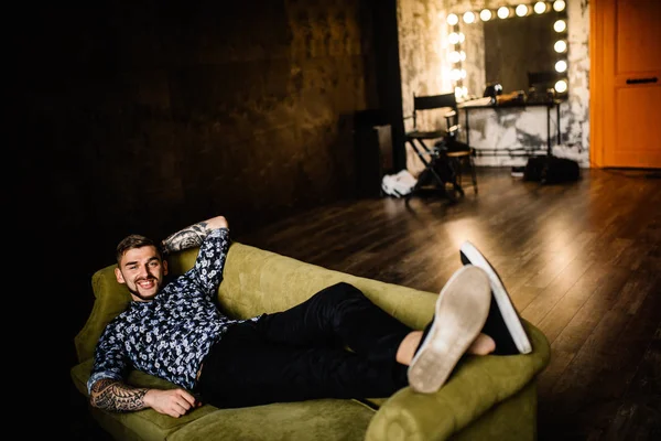 Genç yakışıklı adam kanepede poz