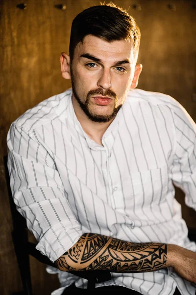 Stüdyoda poz veren genç yakışıklı adam.