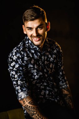 Stüdyoda poz veren genç yakışıklı adam.