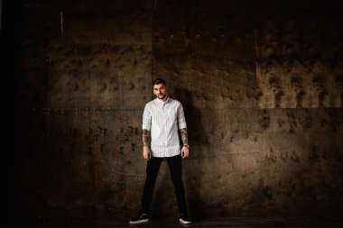 Stüdyoda poz veren genç yakışıklı adam.