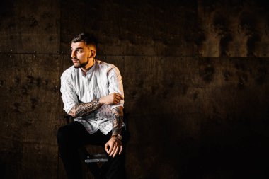 stüdyoda oturan genç yakışıklı adam