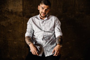 Stüdyoda poz veren genç yakışıklı adam.