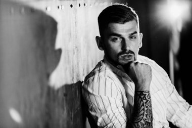 Stüdyoda poz veren genç yakışıklı adam.