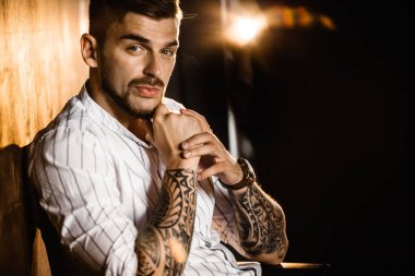 Stüdyoda poz veren genç yakışıklı adam.