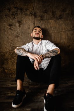 stüdyoda oturan genç yakışıklı adam