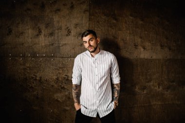 Stüdyoda poz veren genç yakışıklı adam.