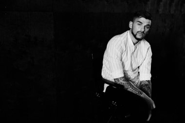 stüdyoda oturan genç yakışıklı adam