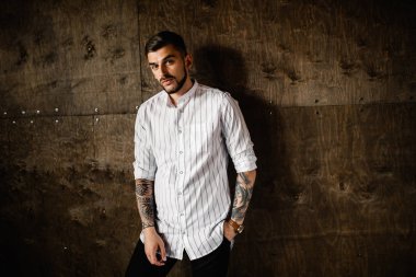 Stüdyoda poz veren genç yakışıklı adam.