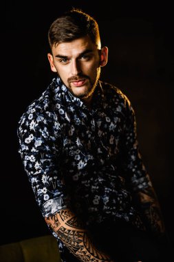 Stüdyoda poz veren genç yakışıklı adam.