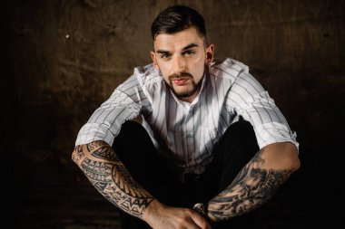 stüdyoda oturan genç yakışıklı adam