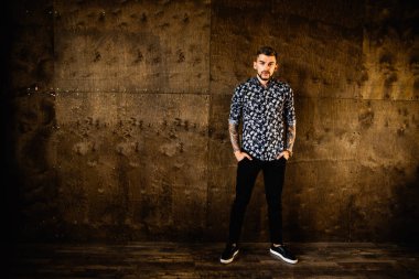 Stüdyoda poz veren genç yakışıklı adam.