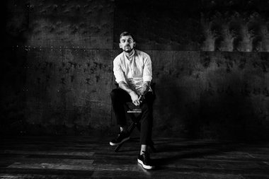 stüdyoda oturan genç yakışıklı adam