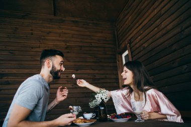 Kahvaltı mutlu güzel genç bir çift. kadın besleme adam 