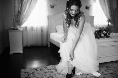 Genç ve güzel gelin ayakkabılarını giyiyor.