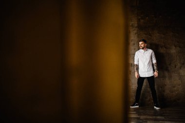 Stüdyoda poz veren genç yakışıklı adam.