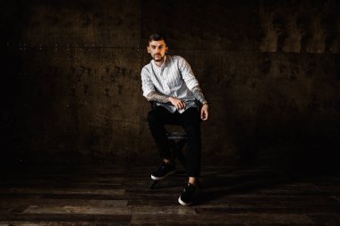 stüdyoda oturan genç yakışıklı adam