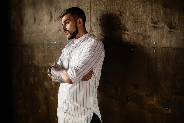 Stüdyoda poz veren genç yakışıklı adam.