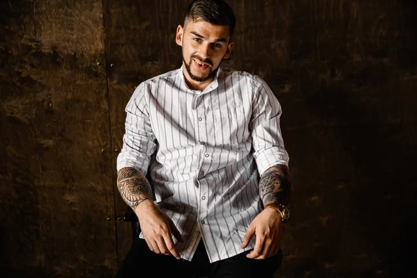 Stüdyoda poz veren genç yakışıklı adam.