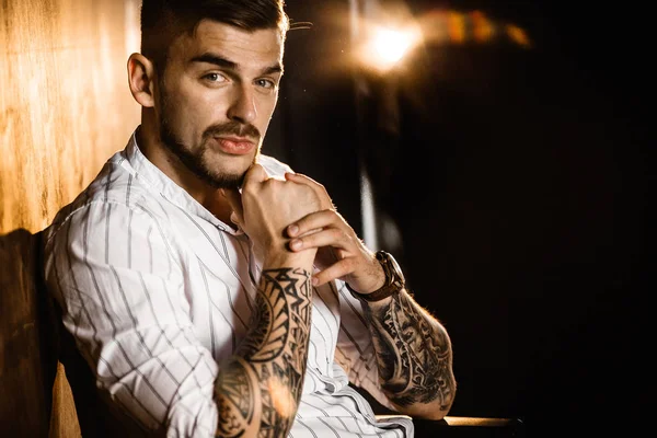 Stüdyoda poz veren genç yakışıklı adam.