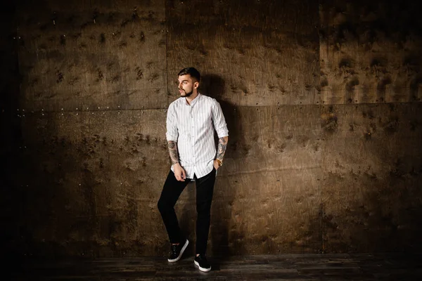 Stüdyoda poz veren genç yakışıklı adam.