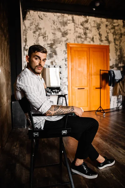 stüdyoda oturan genç yakışıklı adam